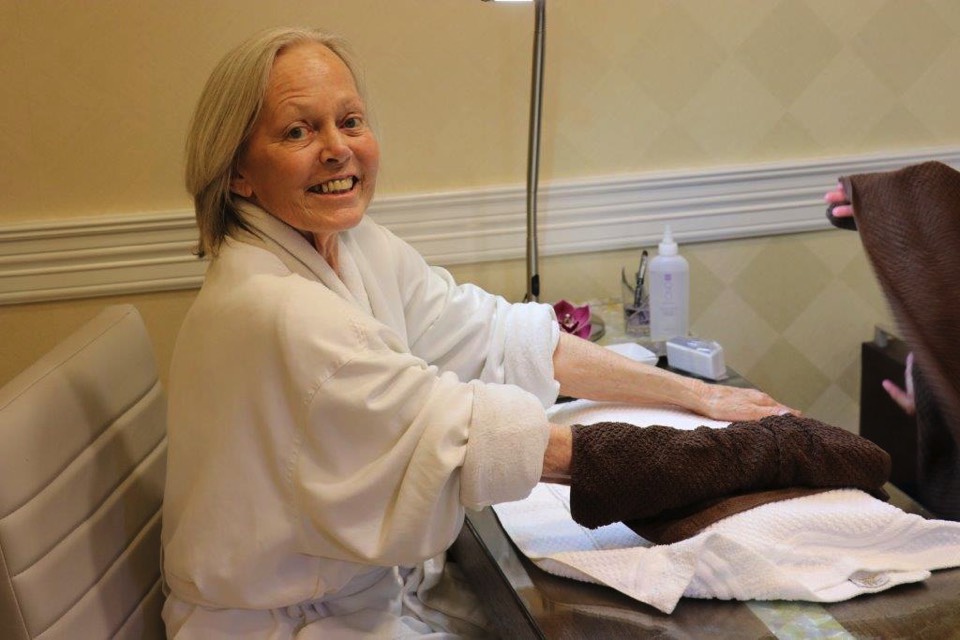 woman in white robe receiving a manicure enjoying The Power of WOW experience 