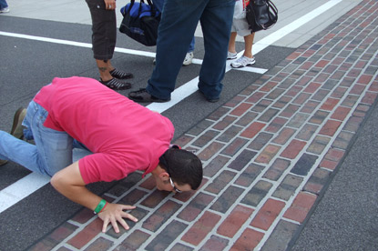 man kissing brick walkway on JAJF trip 