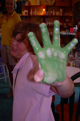 young girl with green paint on her hands making inheritable memories 