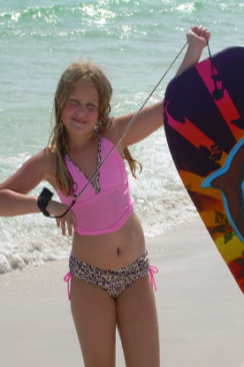 young girl on JAJF trip with her boogie board on the beach 
