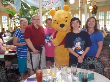family with Winnie the Pooh character enjoying The Power of WOW experience 