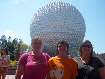 family posing in front of Epcot at Disney World enjoying The Power of WOW experience 