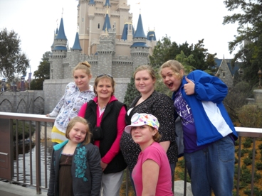 JAJF family posing in front of Disney castle receiving the WOW! Experience! 