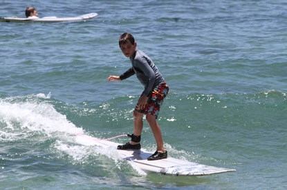 Jack and Jill Foundation boy on surfboard in ocean 
