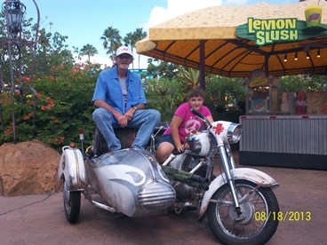 JAJF dad and daughter on parked motorcycle at theme park 