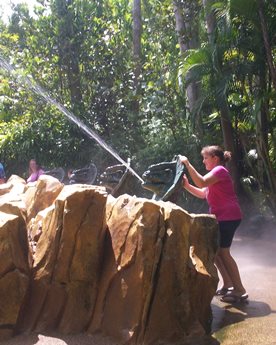 woman with water hose at theme park taking a timeout from late stage cancer 