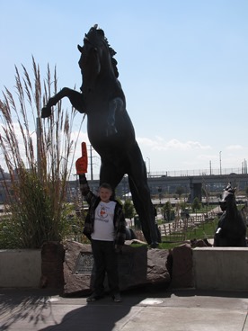 young boy at bronco statue enjoying a timeout from late stage cancer 