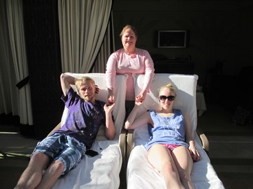 JAJF family on lounge chairs in cabana by pool 