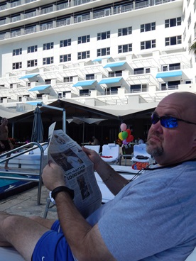 JAJF man reading newspaper poolside 