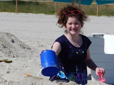 young girl on beach making sandcastles  
