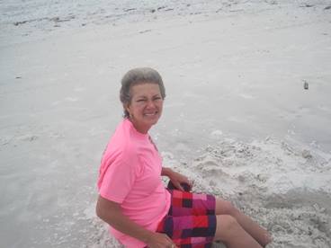 woman sitting on the beach enjoying a break from late stage cancer 