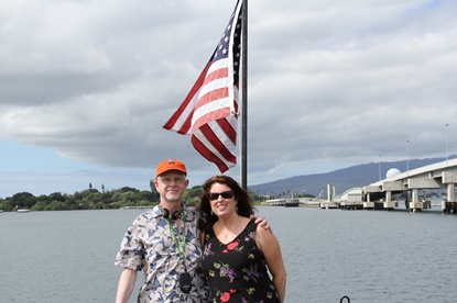 couple on waterfront next to American flag 