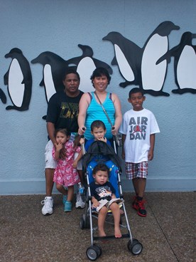 family posing with penguin mural during late stage cancer timeout 