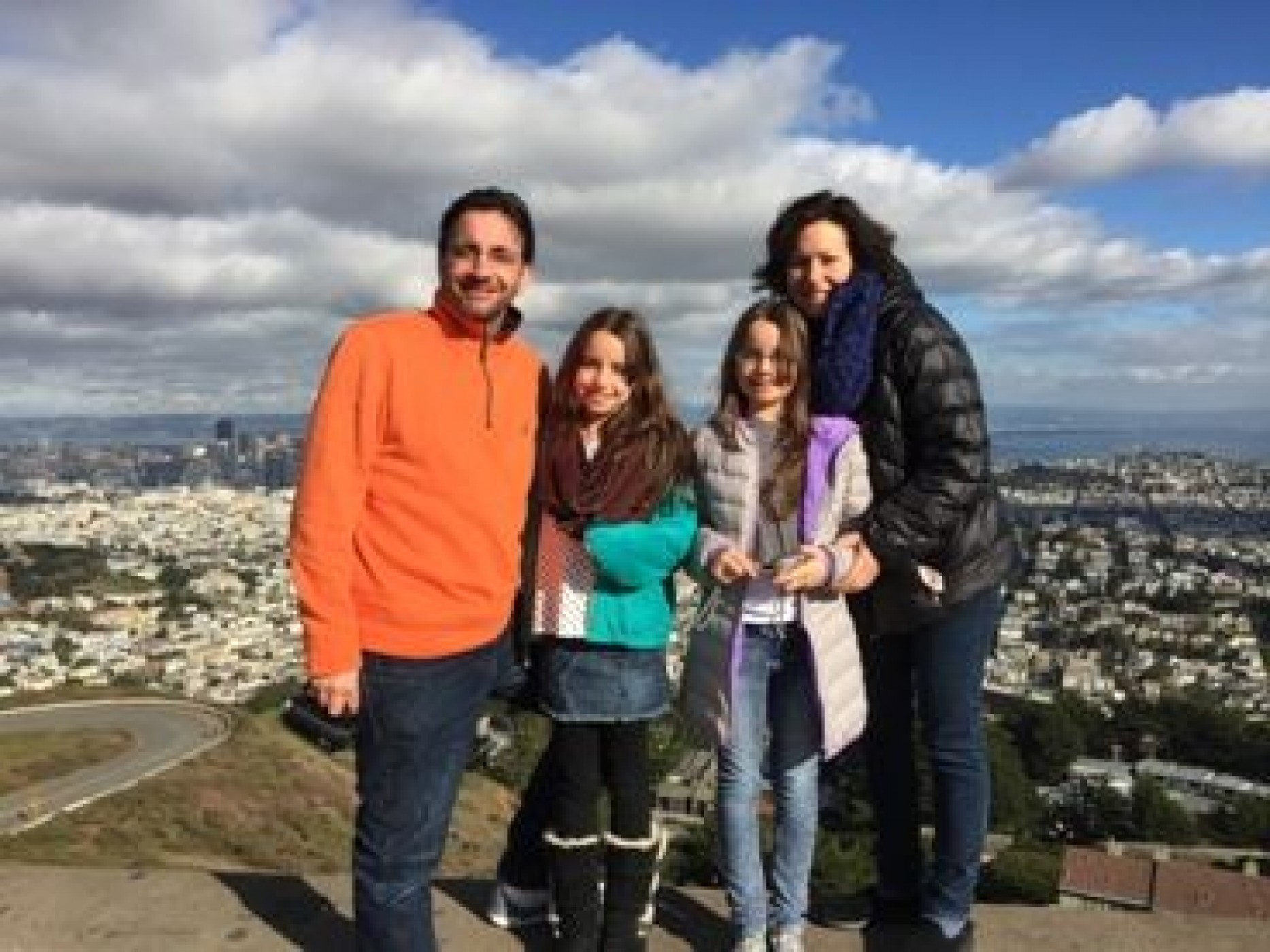 family on mountain overlooking city during a JAJF WOW experience 