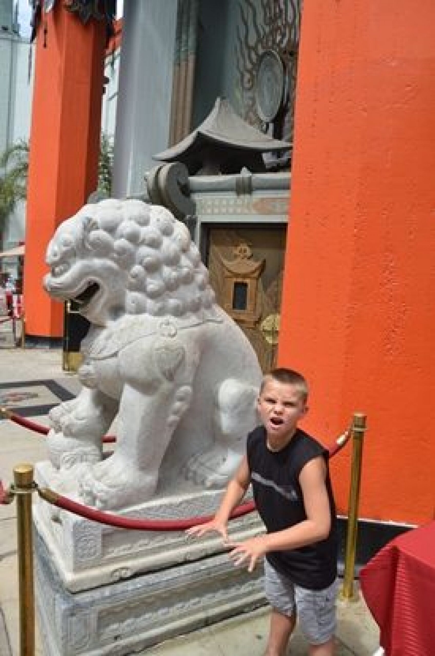 young boy with The Chinese Theater lion statue during a JAJF WOW experience 