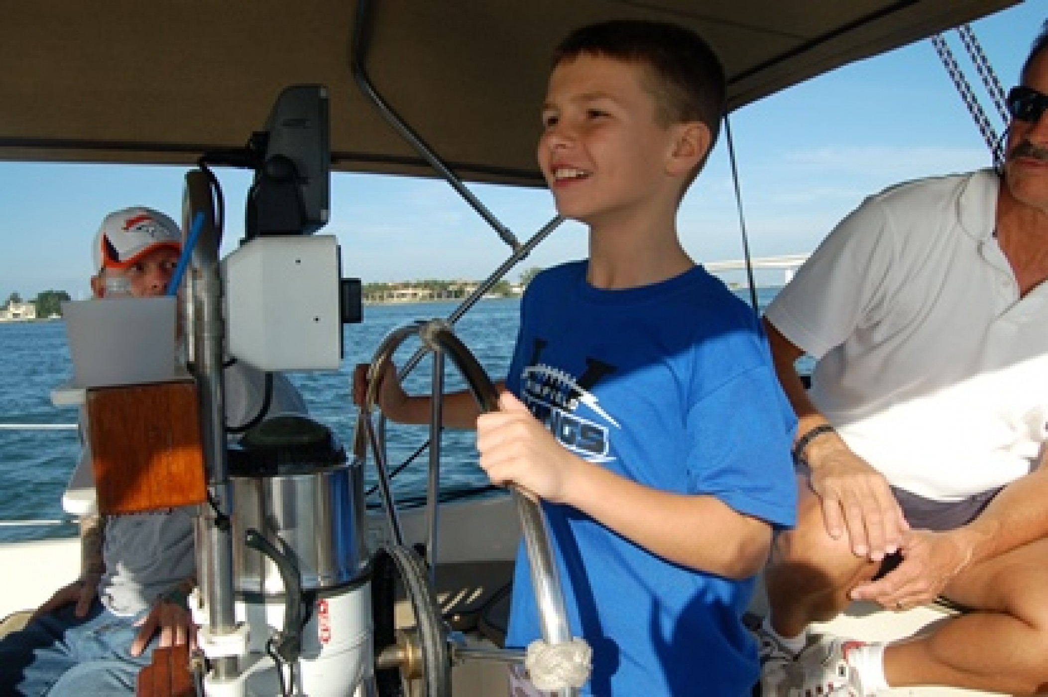 young boy steering a sailboat during a JAJF WOW experience 