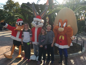 family with Looney Tunes characters during a JAJF WOW experience 