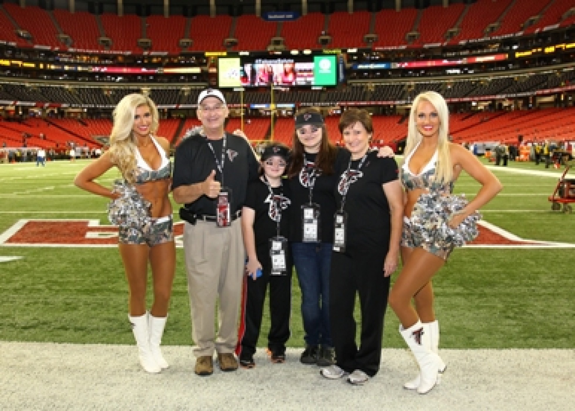 family with Atlanta Falcons cheerleaders during a JAJF WOW experience 