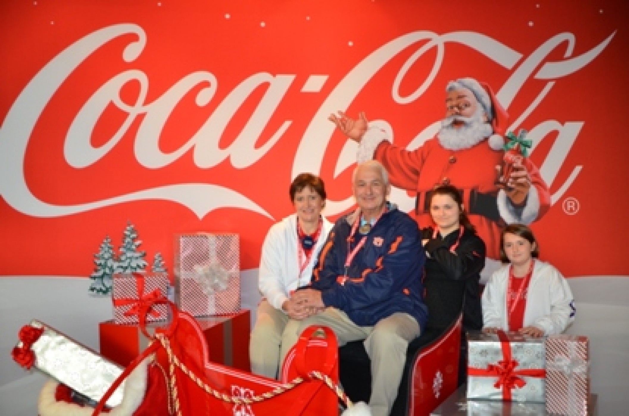 family in front of Coca Cola Christmas mural during a JAJF WOW experience 