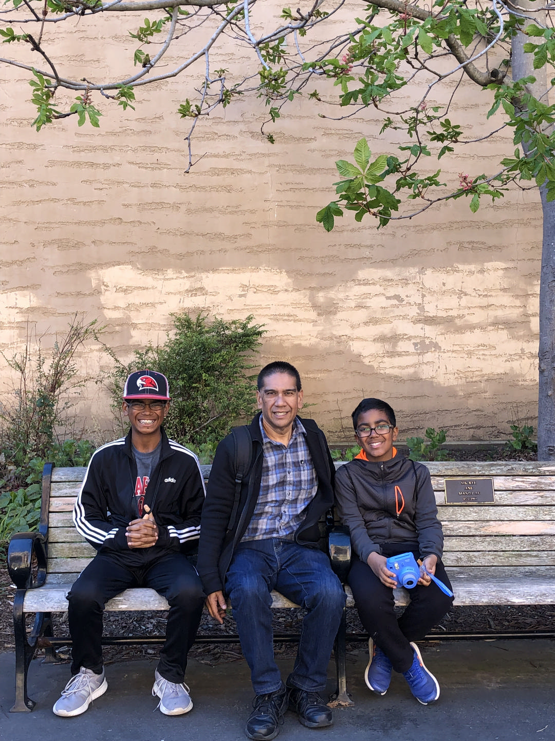 dad and sons on a bench enjoying a JAJF break from late stage cancer 