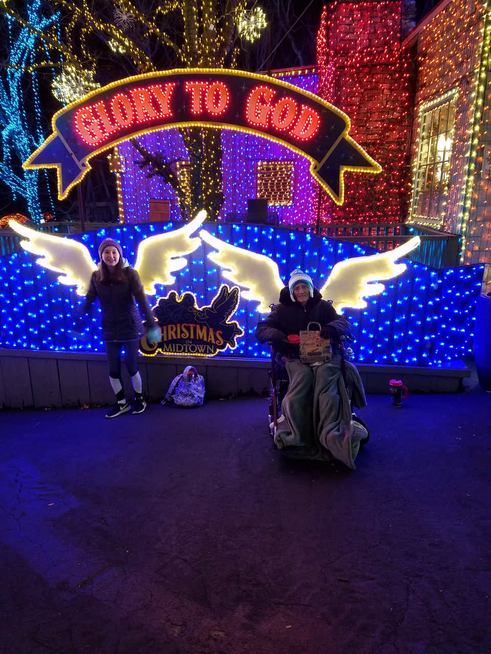 mom and daughter in front of Christmas light displaying enjoying a late stage cancer timeout 