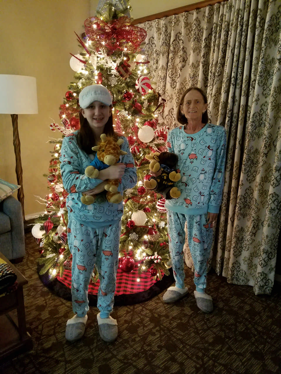 mom and daughter in matching pajamas in front of Christmas tree enjoying a JAJF late stage cancer timeout 