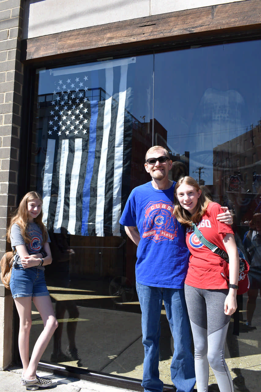 dad and daughters posing with blue lives matter flag 