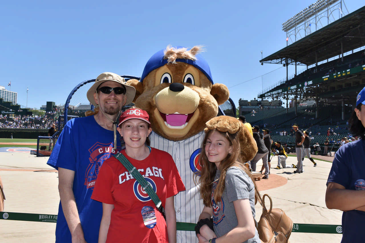 dad and children at Chicago Cub baseball game with Cub mascot 