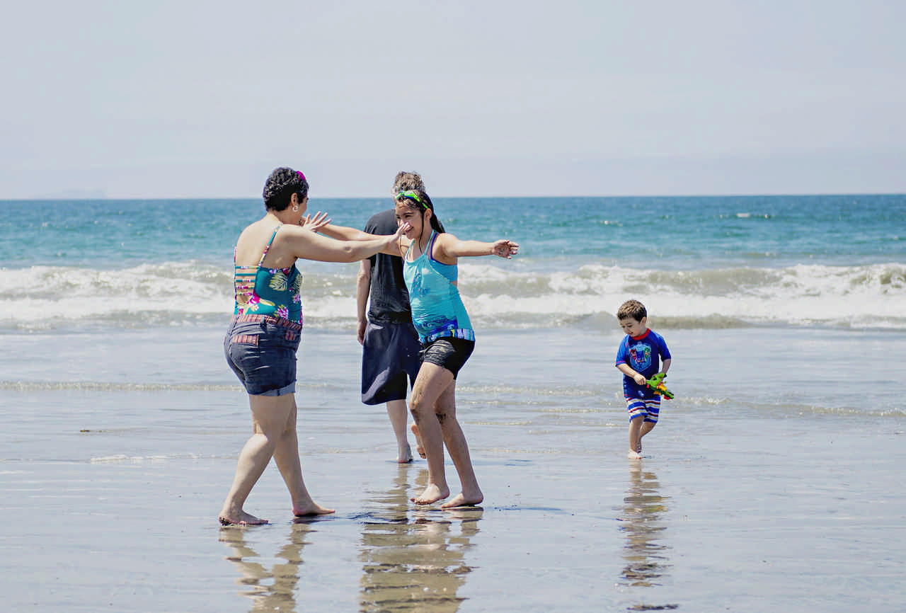 mom and daughter about to hug on the beach during a JAJF cancer timeout 
