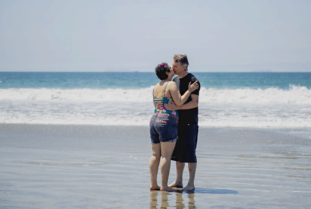 couple embracing on the beach during a JAJF cancer timeout 