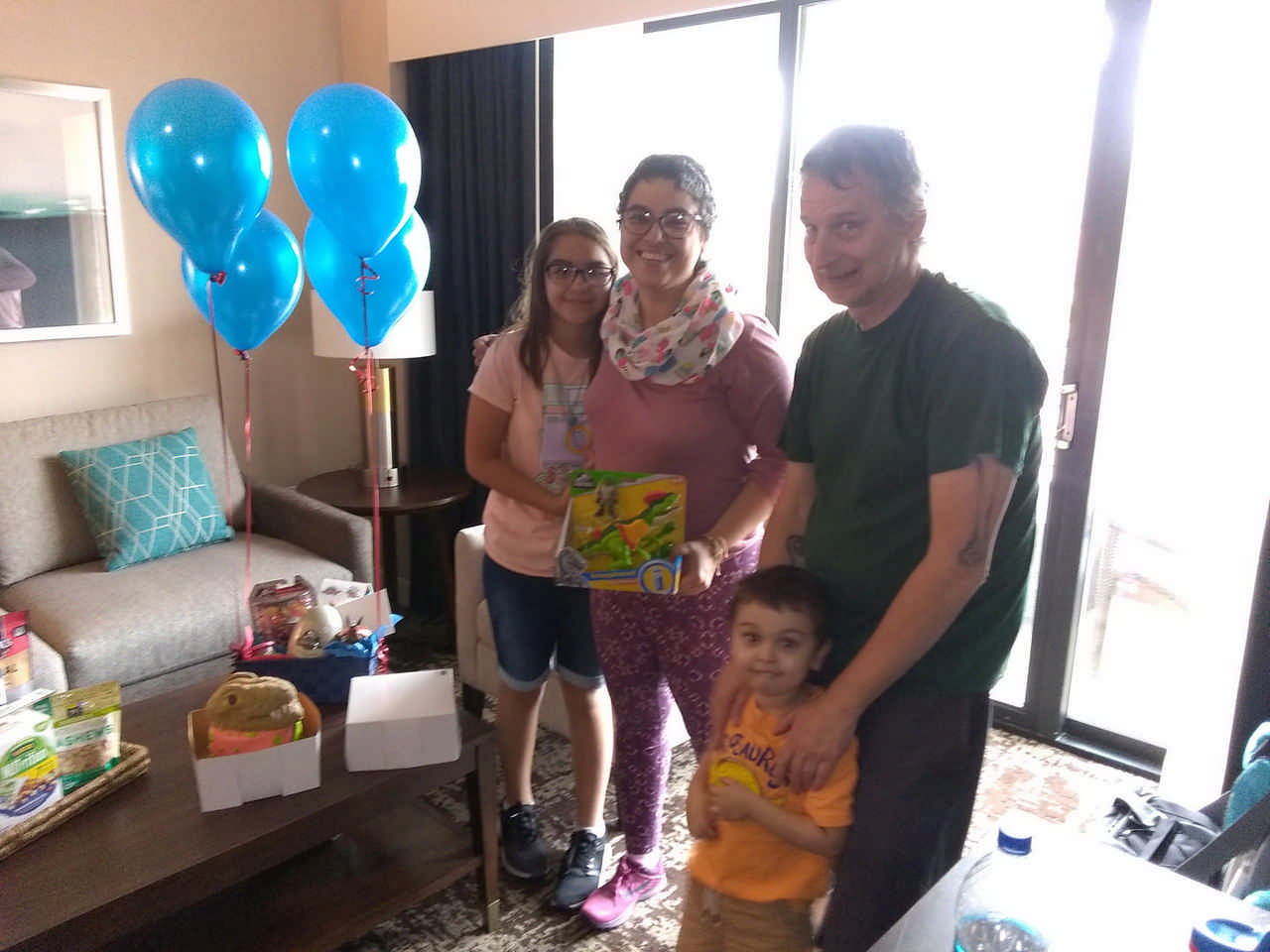 family in hotel room with gift basket during a JAJF cancer timeout 