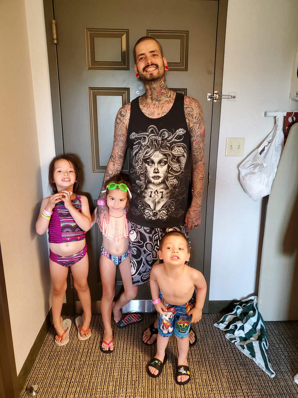 children posing with dad in hotel room during a JAJF cancer timeout 