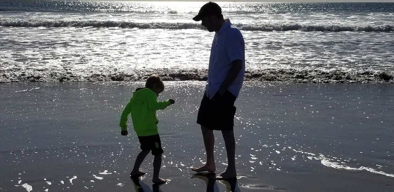 dad and son at sunset on the beach during a JAJF late stage cancer timeout 