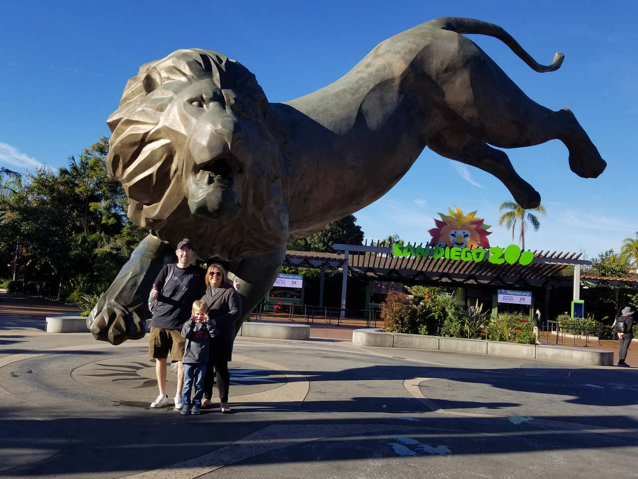 family at San Diego Zoo posing at lion statue enjoying a Jack and Jill Foundation WOW experience 