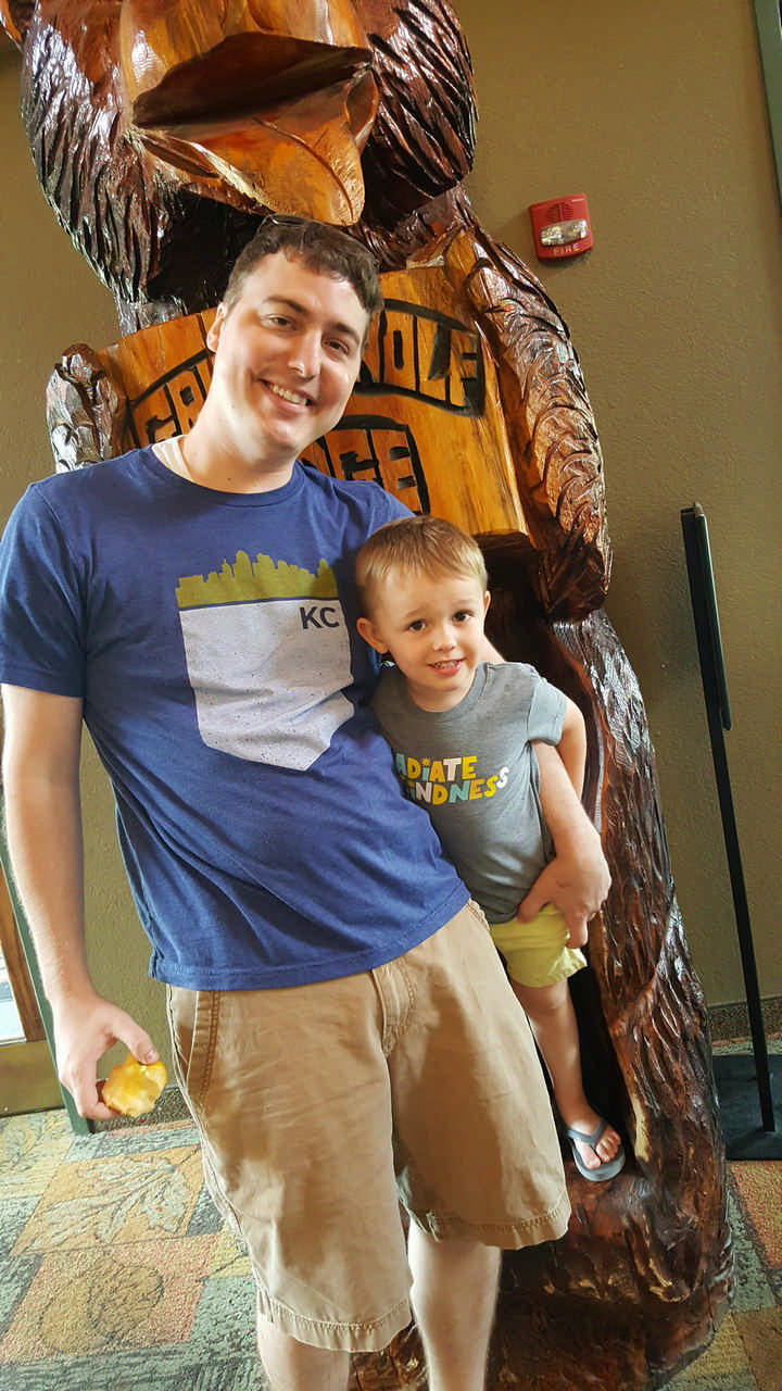 dad and son with Great Wolf Lodge carved bear statue on JAJF WOW experience 