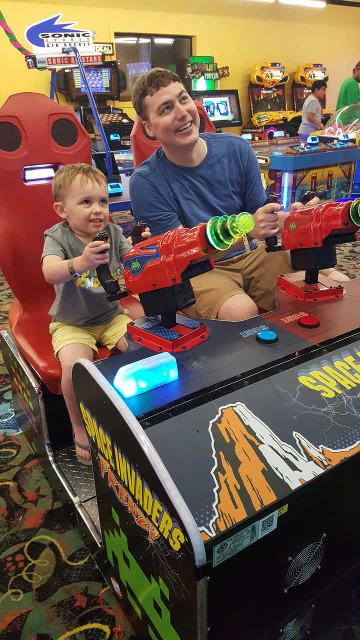dad and toddler son playing in arcade on a Jack and Jill Foundation WOW experience 