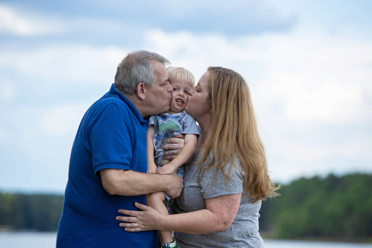 couple kissing toddler between them during a Jack and Jill Foundation WOW experience 