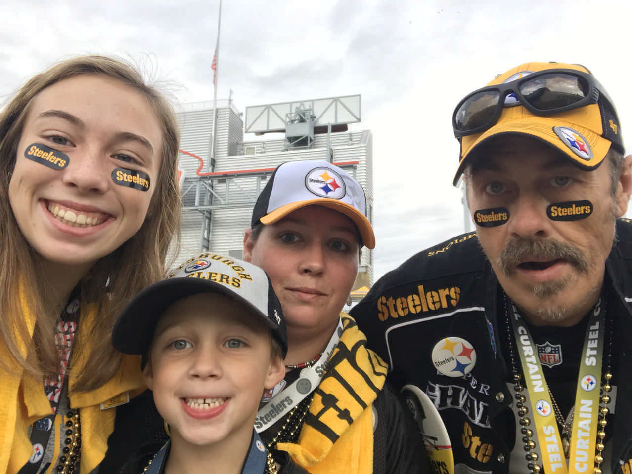 family dressed in Pittsburgh Steelers gear at Pittsburgh Steelers game 