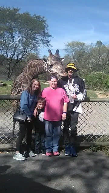 family posing with giraffe during a Jack and Jill Foundation WOW experience 