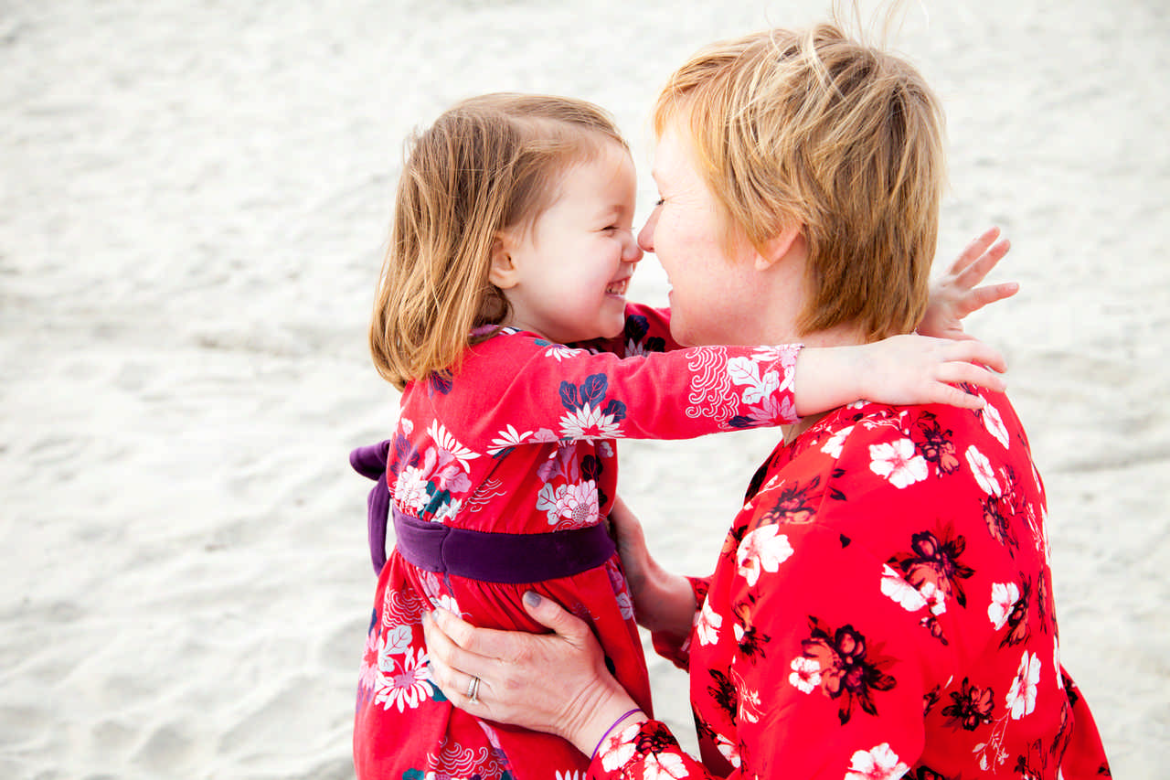 mom touching noses with her daughter on the beach during a JAJF WOW experience 