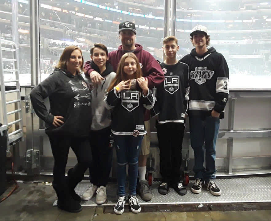 family posing at LA Kings hockey game enjoying a JAJF WOW experience 