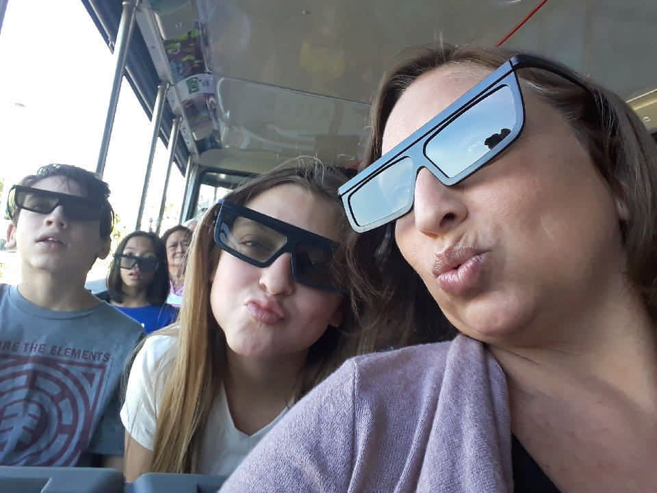 A mother and her children take a selfie with sunglasses on.  