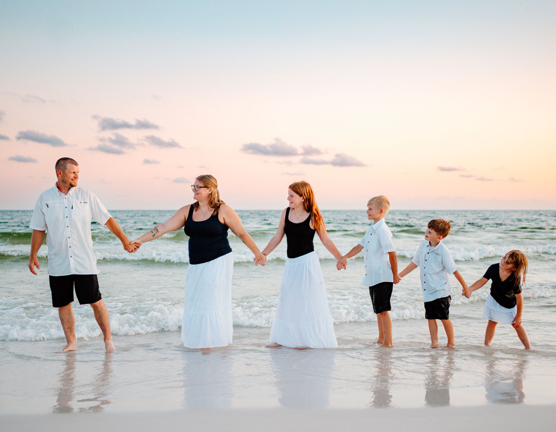 JAJF family holding hands on the beach at sunset during their oncology prescribed timeout from cancer.
