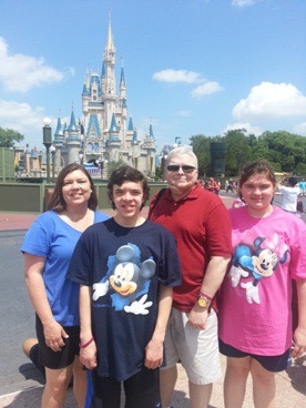 family posing in front of Cinderella's castle at Disney World enjoying The Power of WOW experience 