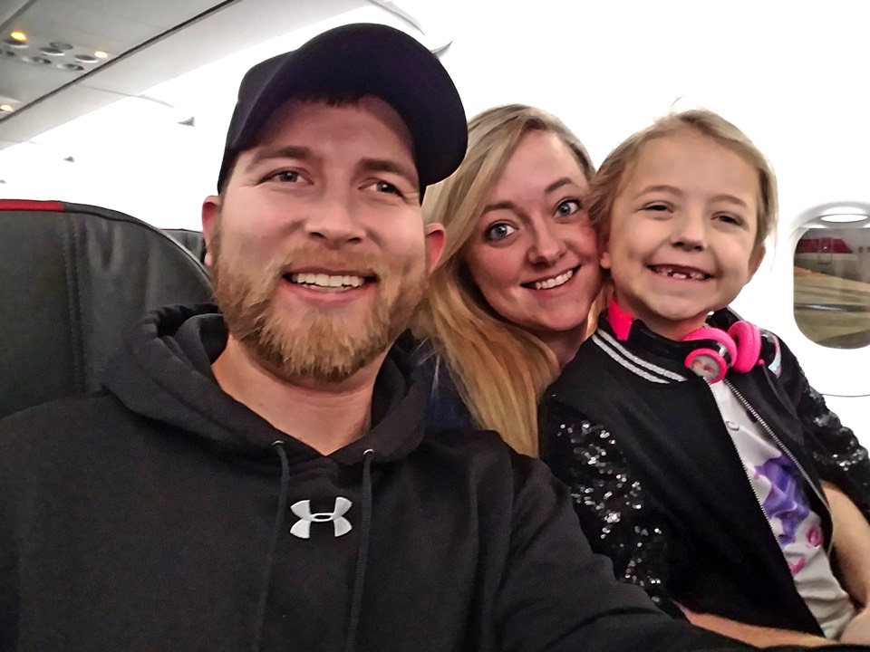couple with daughter on airplane enjoying The Power of WOW experience 