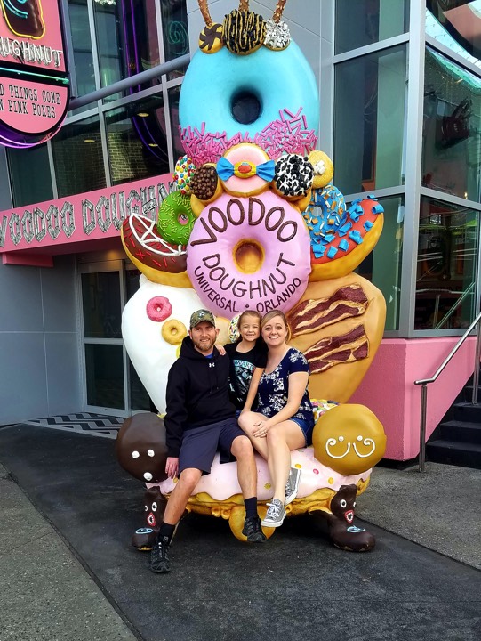 couple with daughter at Voodoo Doughnut enjoying The Power of WOW experience 