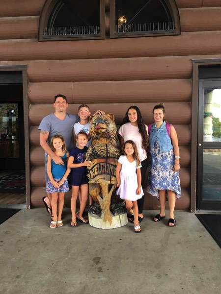 family with Great Wolf Lodge statue enjoying a JAJF WOW experience 