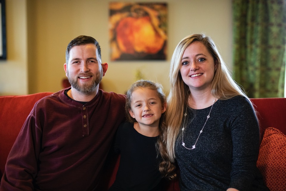 couple with daughter on couch enjoying The Power of WOW experience 
