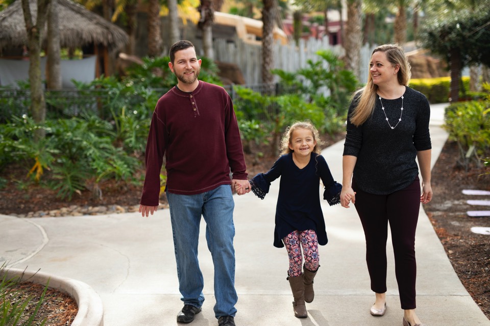 JAJF couple holding hands with their daughter enjoying The Power of WOW experience 