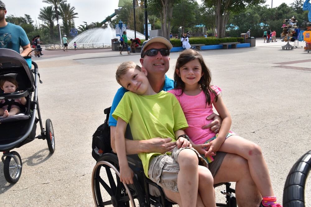children sitting with dad in wheelchair enjoying The Power of WOW experience 